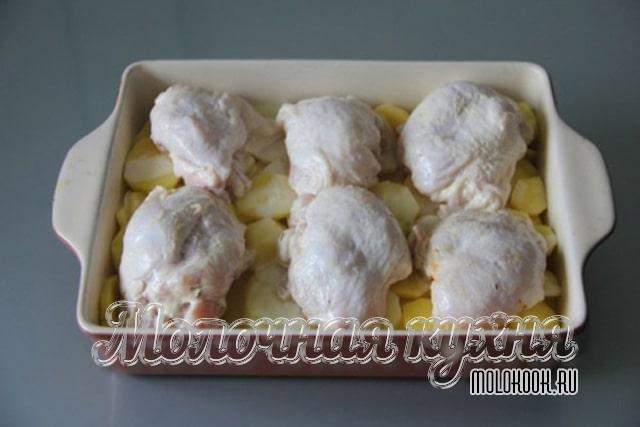 Куриные бедра выложены поверх картофеля